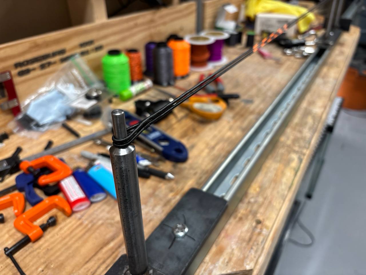 Two control cables placed on the same jig posts for a length comparison check
