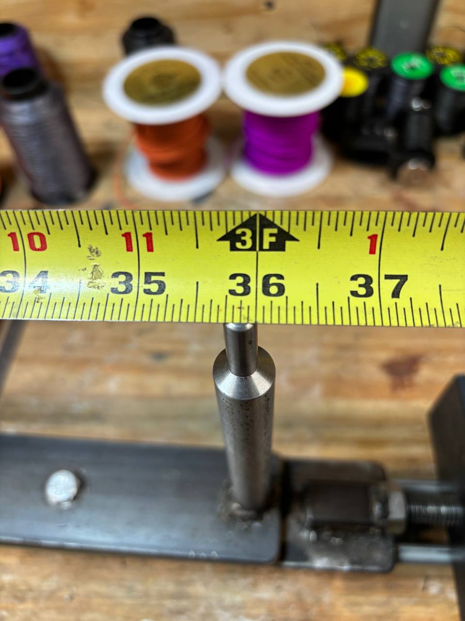 A tape measure laid across the jig with the reading taken from the outside face of the main post.