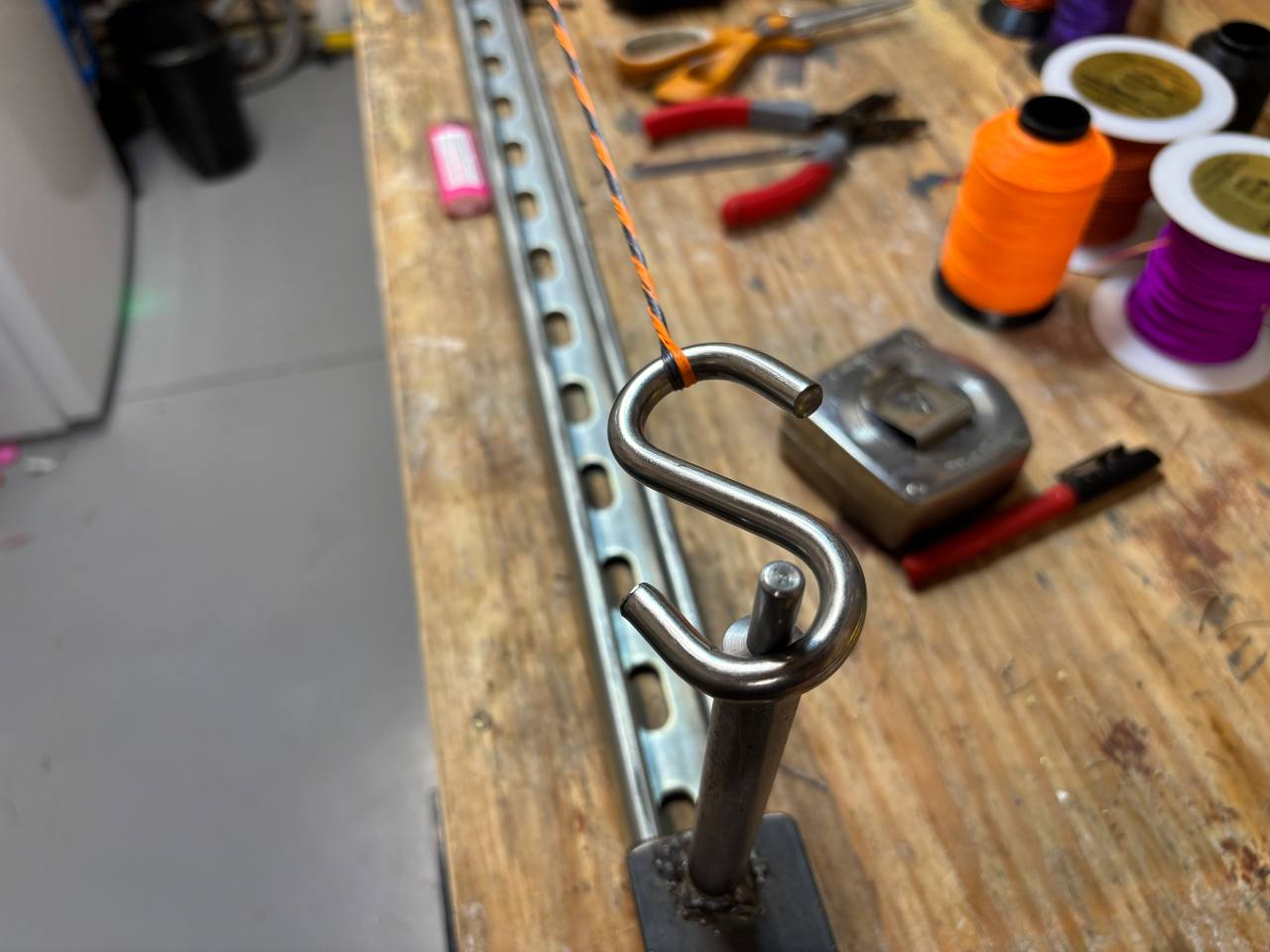 A real S-hook termination at the working end of the bundle, with the loop seated at the top of the hook before further twisting or measurement.