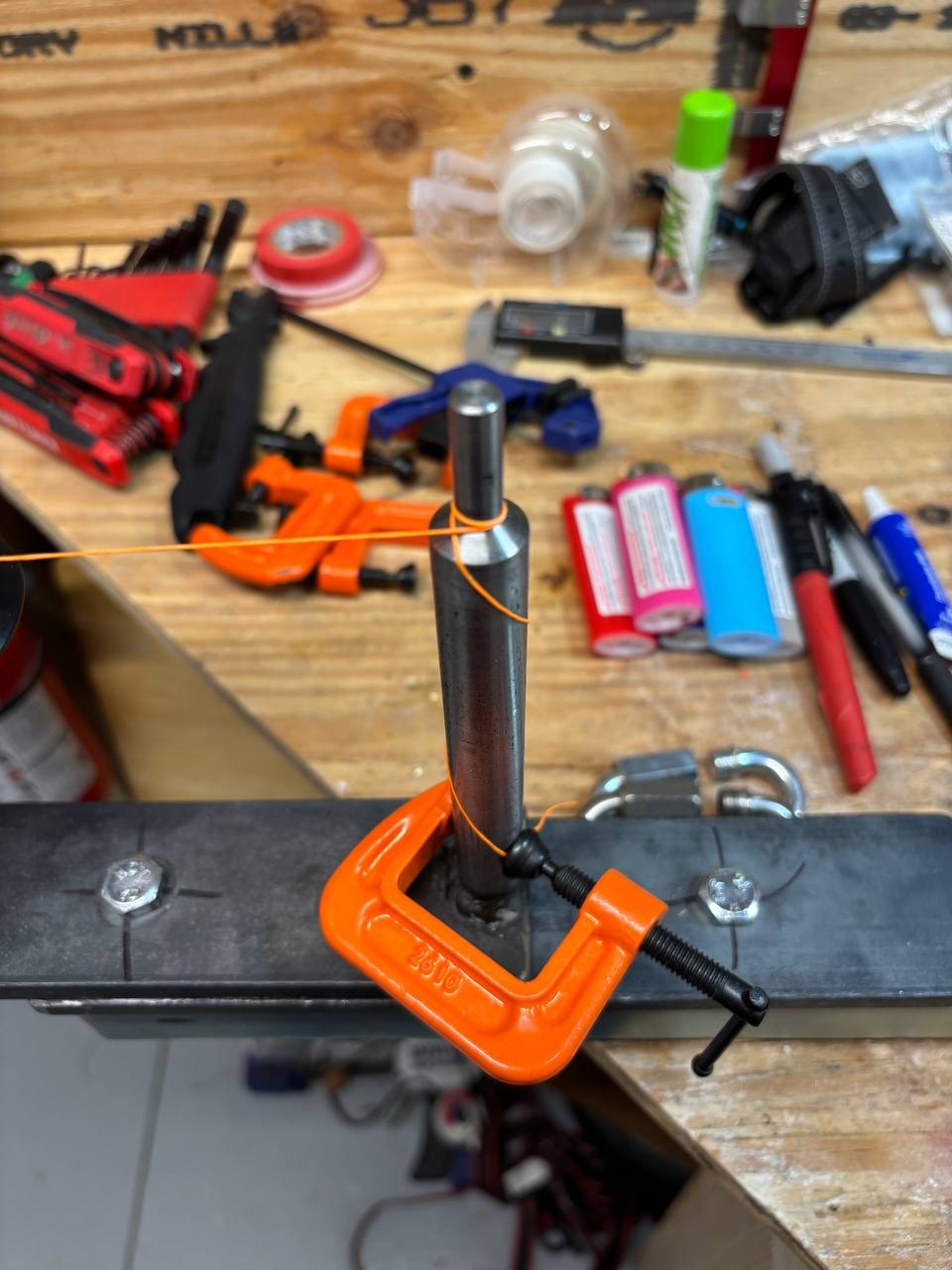 The tag end wrapped on the auxiliary post and mechanically restrained before the rest of the layup continues.